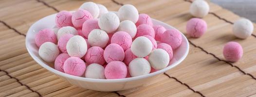 Raw red and white tangyuan on wooden table background for Winter solstice food. photo