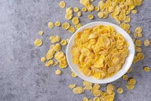Corn flakes bowl sweets on gray cement background, top view flat lay layout design, fresh and healthy breakbast concept. photo
