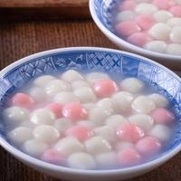 Close up of red and white tangyuan in blue bowl on wooden background for Winter solstice. photo