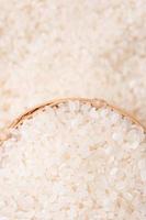 Raw rice in a bowl and full frame in the white background table, top view overhead shot, close up photo