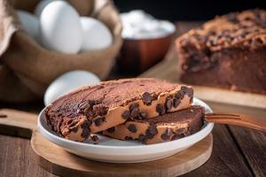 Chocolate flavor Taiwanese traditional sponge cake Taiwanese castella kasutera on a wooden tray background table with ingredients, close up. photo