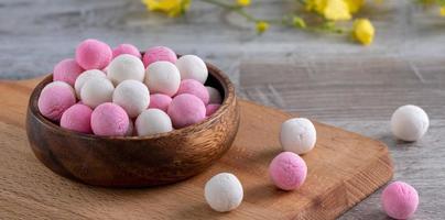 tangyuan rojo y blanco crudo sobre fondo de mesa de madera para la comida del solsticio de invierno. foto