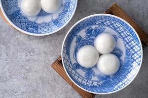 Top view of tangyuan in a bowl on gray background for lunar new year food. photo