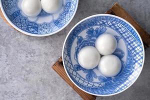 vista superior de tangyuan en un tazón sobre fondo gris para la comida del año nuevo lunar. foto