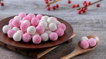 Raw red and white tangyuan on wooden table background for Winter solstice food. photo