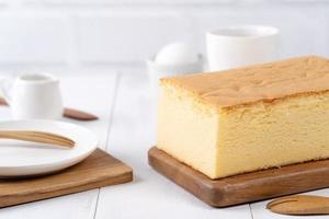 Plain classic Taiwanese traditional sponge cake Taiwanese castella kasutera on a wooden tray background table with ingredients, close up. photo