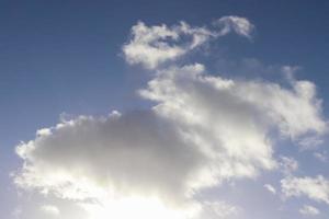 Beautiful fluffy white cloud formations in a deep blue summer sky photo