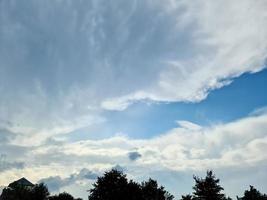 Beautiful fluffy white cloud formations in a deep blue summer sky photo