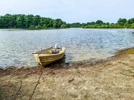 Rowboat lying at the coast of a lake on a sunny day photo