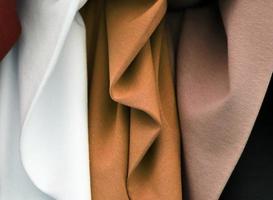 Detailed close up view on samples of cloth and fabrics in different colors found at a fabrics market photo