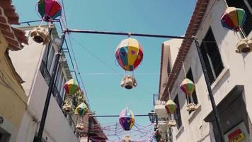 des lanternes en papier décorent le chemin entre deux bâtiments de la ville pour une fête de quartier video