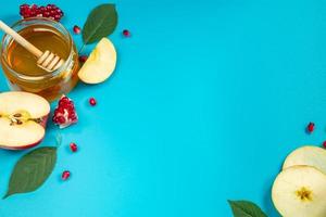 Honey, apples and pomegranates on blue background. Happy Rosh Hashanah. Jewish traditional religious holiday. photo