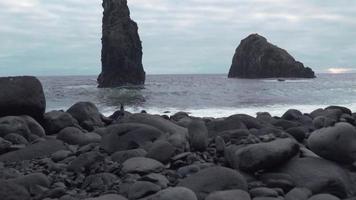 de grandes formations rocheuses dans la mer alors que les vagues s'écrasent sur un rivage pierreux video
