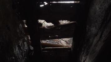 Looking through the broken paneling of an old door from abandoned building video