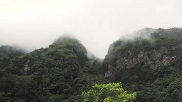 Fog rolling over mossy rock mountains video