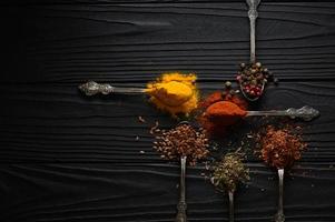 Colorful various herbs and spices for cooking on dark wooden rustic background photo