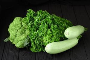 Still life of green vegetables on black background photo
