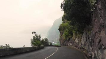 dirigindo por uma estrada de montanha com vista para o mar à esquerda video