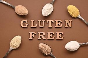 Gluten free text and spoons of various gluten free flour. Flat lay, top. photo