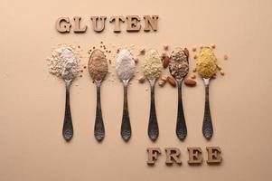 Gluten free text and spoons of various gluten free flour. Flat lay, top. photo