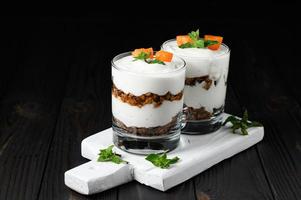 Homemade layered dessert with fresh apricot, cream cheese or yogurt, granola on rustic background. photo