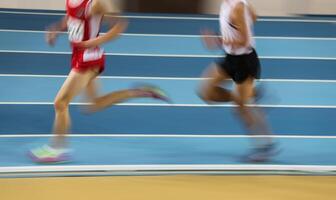 Blured athletes run in track and field photo