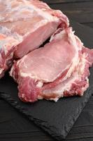 A large piece of pork loin on a rustic dark background. photo