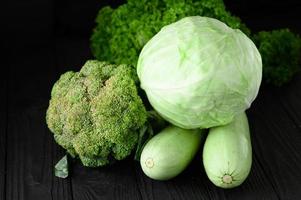 bodegón de verduras verdes sobre fondo negro foto