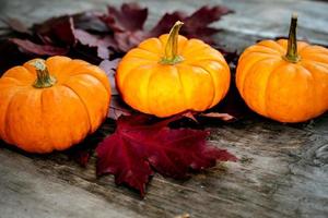 Festive autumn decor from pumpkins, pine and leaves on a  wooden background. Concept of Thanksgiving day or Halloween. Flat lay autumn composition with copy space. photo