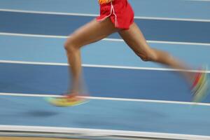 Blured athletes run in track and field photo