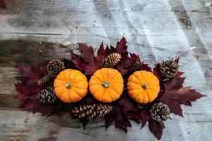 Festive autumn decor from pumpkins, pine and leaves on a  wooden background. Concept of Thanksgiving day or Halloween. Flat lay autumn composition with copy space. photo