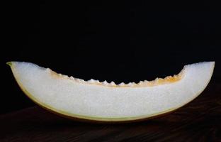 A piece of ripe melon on a black background. photo