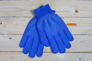 Blue gloves on wooden table photo