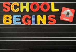 Back to school concept with colorful magnetic letters on a chalkboard as a black background. There is a free text field. photo