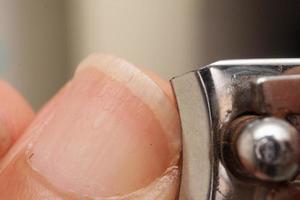 Man trimming his fingernails with a pair of nail trimmers photo