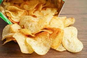Potato chips in open bag, delicious BBQ seasoning spicy for crips, thin slice deep fried snack fast food in open bag. photo