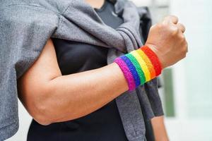 mujer asiática con bandera del arco iris, derechos de símbolos lgbt e igualdad de género, mes del orgullo lgbt en junio. foto