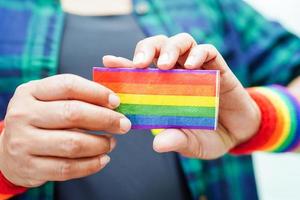 Asian woman with rainbow flag, LGBT symbol rights and gender equality, LGBT Pride Month in June. photo