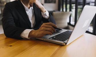 hombre de negocios y equipo analizando la tarea financiera de los estados financieros. con teléfono inteligente y computadora portátil y tableta. concepto de gestión de riqueza foto