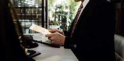 Business and lawyers discussing contract papers with brass scale on desk in office. Law, legal services, advice, justice and law concept picture with film grain effect photo