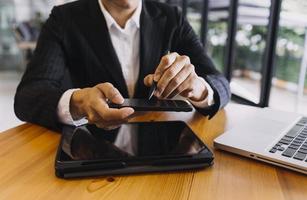 Businessman and team analyzing financial statement Finance task. with smart phone and laptop and tablet. Wealth management concept photo