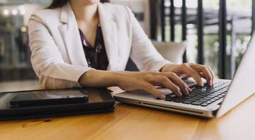 hombre de negocios y equipo analizando la tarea financiera de los estados financieros. con teléfono inteligente y computadora portátil y tableta. concepto de gestión de riqueza foto