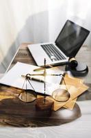 Justice and law concept.Male judge in a courtroom with the gavel, working with, computer and docking keyboard, eyeglasses, on table in morning light photo