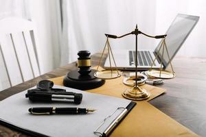 Justice and law concept.Male judge in a courtroom with the gavel, working with, computer and docking keyboard, eyeglasses, on table in morning light photo