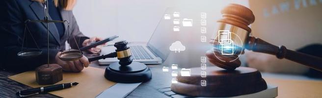 Justice and law concept.Male judge in a courtroom with the gavel, working with, computer and docking keyboard, eyeglasses, on table in morning light photo