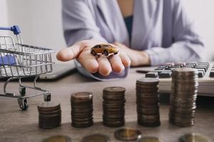 Close up of hand putting coin on pile coins for saving money. Collect money to buy a new car, saving and car loan concept. Flat lay photo