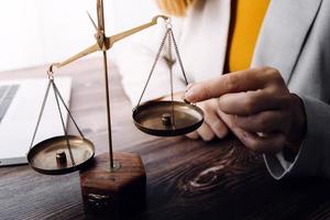 Justice and law concept.Male judge in a courtroom with the gavel, working with, computer and docking keyboard, eyeglasses, on table in morning light photo