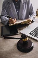 Male lawyer working with contract papers and wooden gavel on tabel in courtroom. justice and law ,attorney, court judge, concept. photo