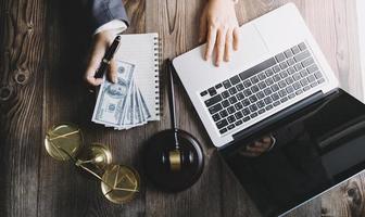 Business and lawyers discussing contract papers with brass scale on desk in office. Law, legal services, advice, justice and law concept picture with film grain effect photo