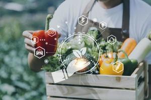 un hombre de negocios futurista cultiva verduras y cultivos usando tecnología moderna de inteligencia artificial usando teléfonos móviles, sensores de temperatura y humedad, rastreo de agua, control climático, íconos de datos holográficos. foto